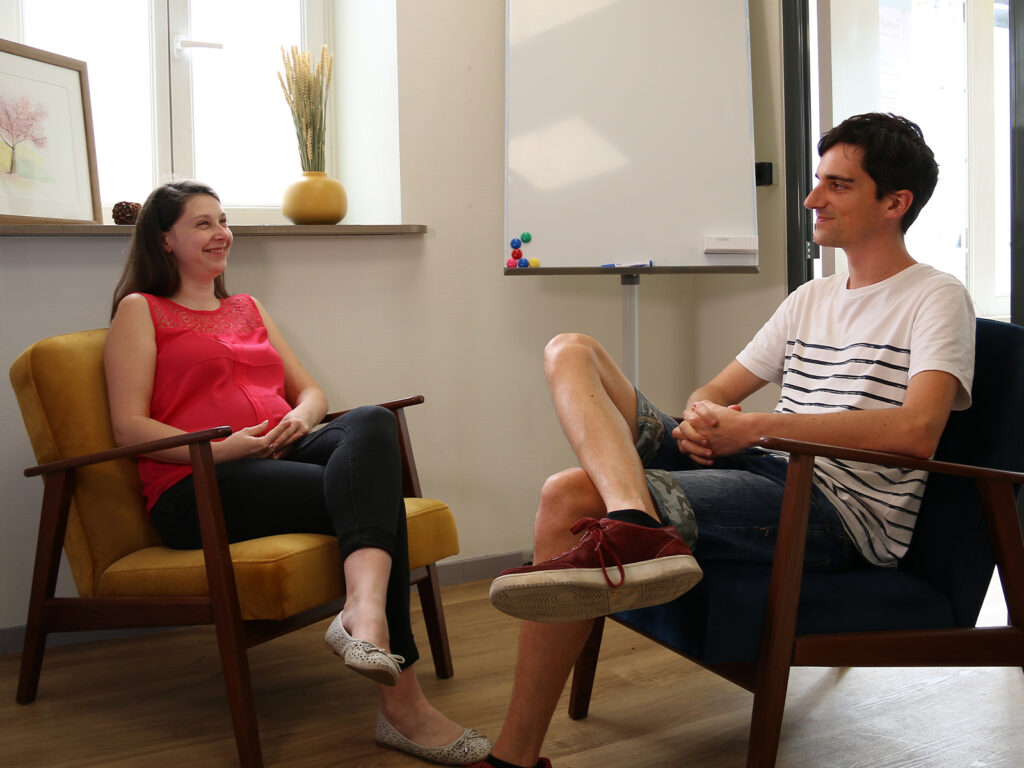 Deux adultes échangent face à face pendant un cours de conversation